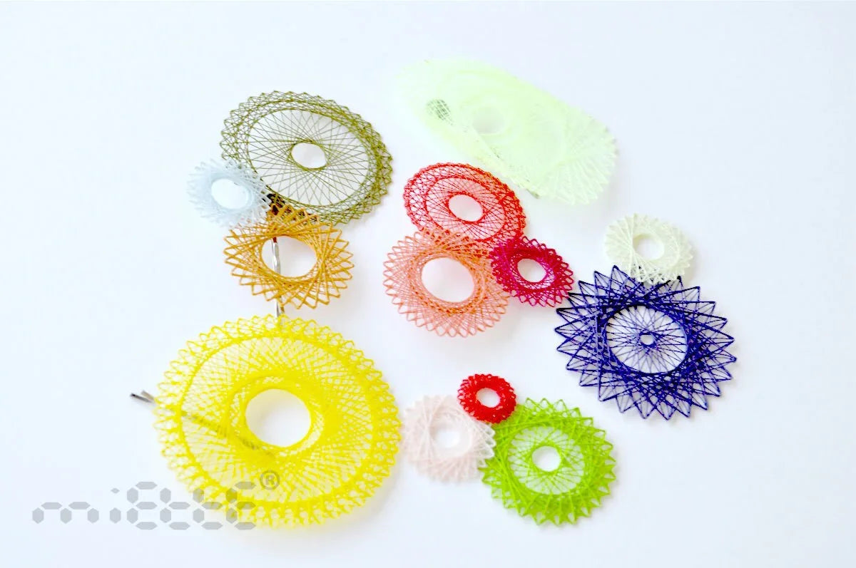 Colorful geometric lace earrings in circular designs arranged on a white background