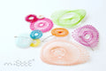 Colorful geometric mesh hair clips and brooches arranged on a white background
