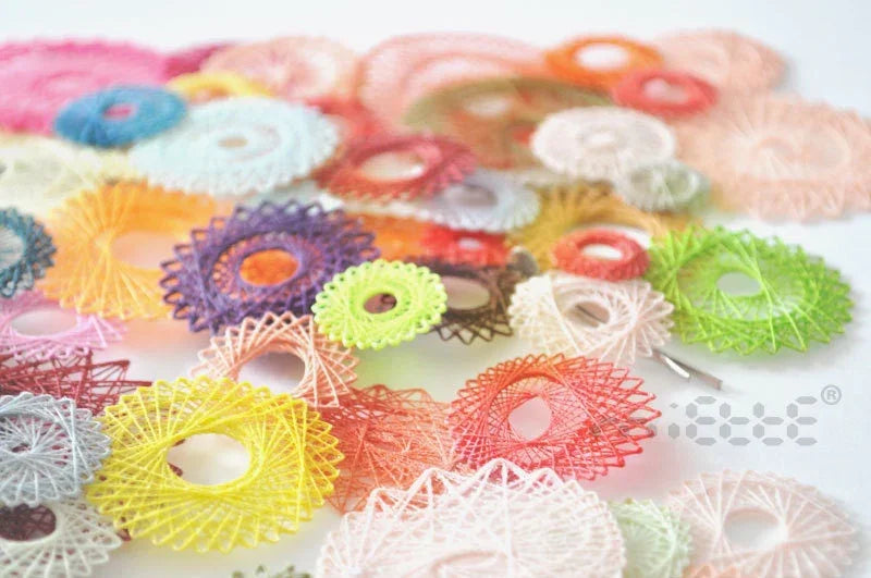 Colorful handmade thread lace discs arranged on a white surface